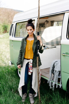 Young woman with spear and facepaint in front of her camper