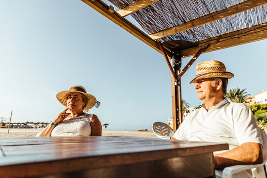 Senior couple sitting at a bar terrace at the beach, El Roc de Sant Gaieta, Spain