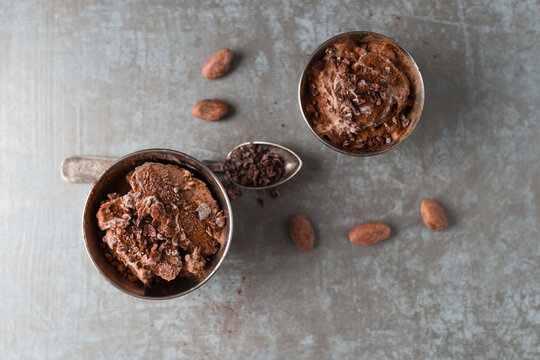 Cups of chocolate icecream sprinkled with cacao and cacao nibs