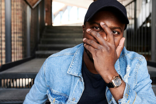 Portrait of man covering face with his hand