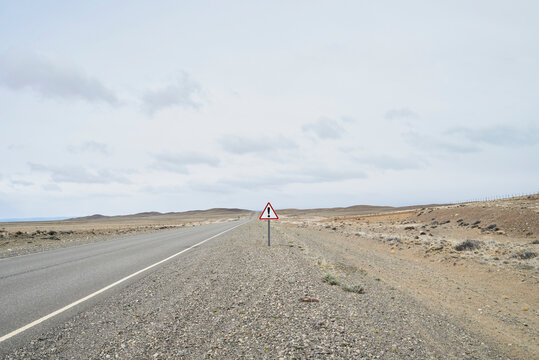 Argentina, Patagonia, Empty road with exclamation mark sign in the middle of desert