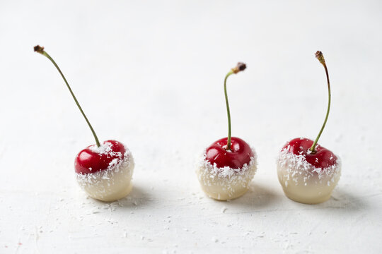 Close-up of cherries covered with white chocolate and grated coconut