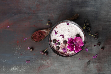Bowl of natural yoghurt with Aronia powder and hollyhock flower