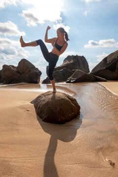 Seychelles, Mahe, Takamaka Beach, woman standing on a rock shadowboxing