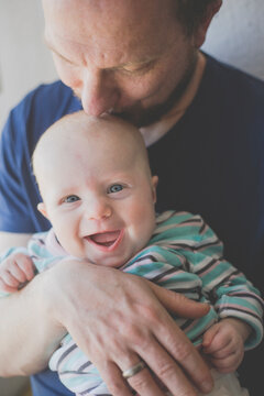 Father kissing his laughing baby daughter