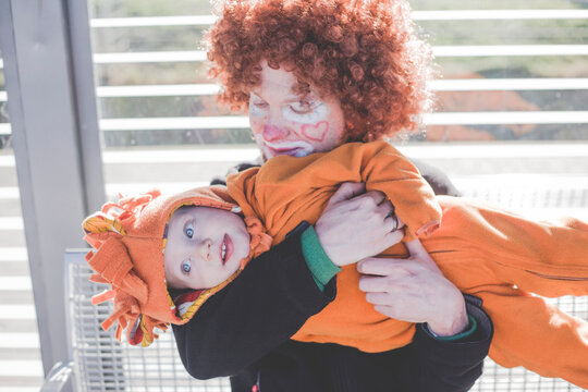 Man dressed up as a clown and little boy dressed up as lion baby at carnival