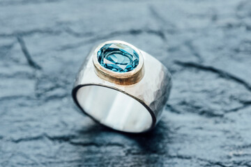 Silver ring with Topaz in gold setting on slate
