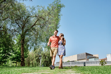 Happy young couple walking trough a park