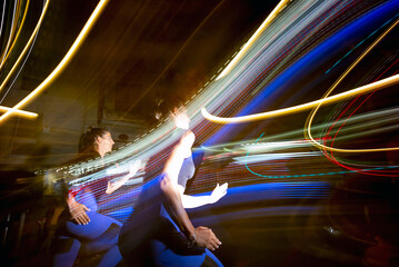Long exposure photo of two women running in the city at night