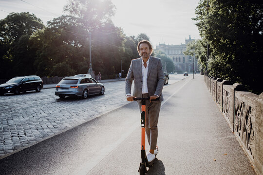 Businessman with e-scooter in the city