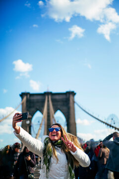 Happ woman taking a selfie on Brooklyn Bridge, New York, United States