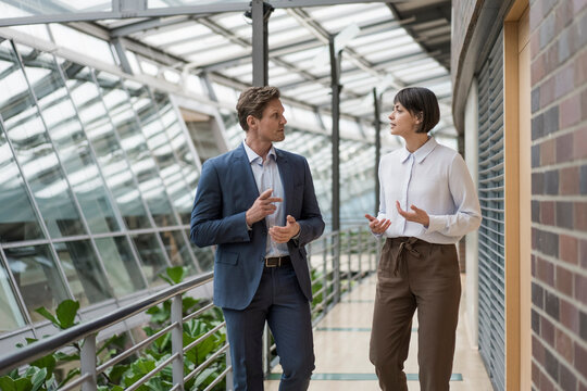Businessman and woman talking in sustainable office building