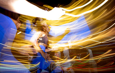 Long exposure photo of two women running in the city at night