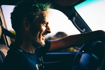 Mature man driving at sunset
