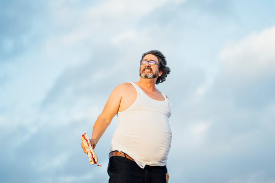 Man with beer belly holding sandwich