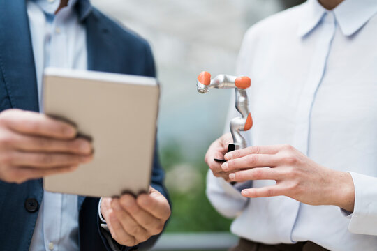 Businessman and woman talking about robot arm