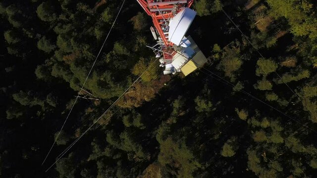 Aerial view of a worker analyzing data of a telecom tower - birdseye, drone shot
