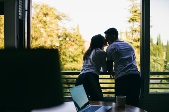 Couple kissing while standing at balcony