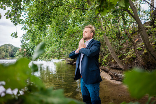 Businessman standing in a lake meditating