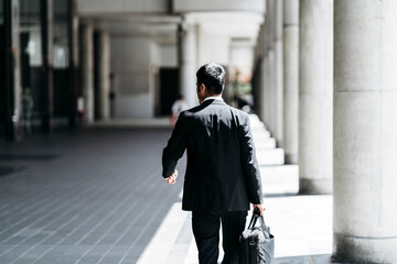 Rear view of young businessman walking in the city