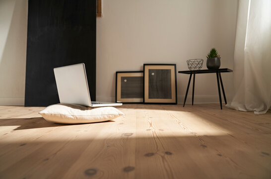 Laptop on cushion and wooden floor in a modern room