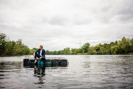 Businessman sitting on a float a lake