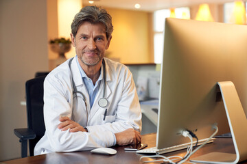 Portrait of confident doctor at desk in his medical practice