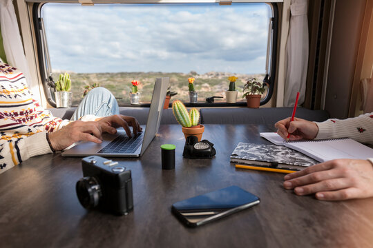 Crop view of couple working in camper, Es Mercadal, Menorca, Spain
