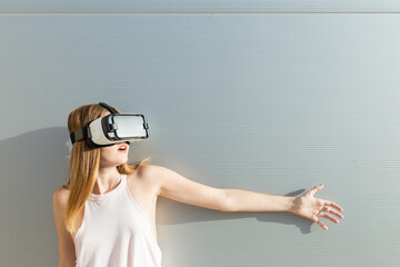 Young woman using Vr googles, reaching with her hand