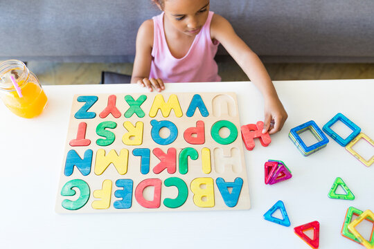 Girl playing with alphabet learning game at home