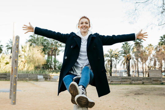 Portrait of happy young woman on a seesaw on playground