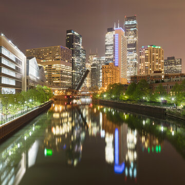 Reflection of illuminated buildings by river during night, Chicago, USA