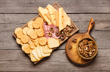 Platter with crunchy crackers and nuts on wooden background
