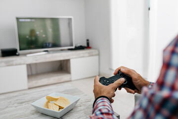 Hands of man playing computer game at home