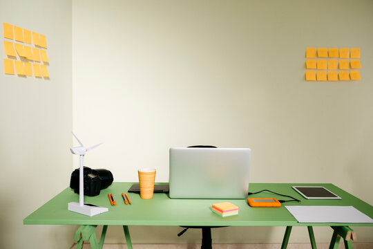 Desk in office with laptop, wind turbine and a camera
