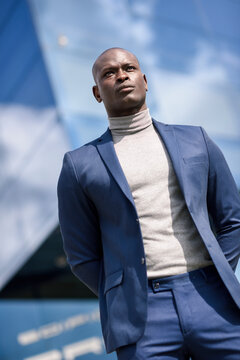 Portrait of businessman wearing blue suit and grey turtleneck pullover