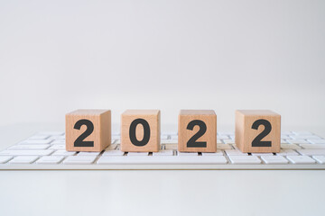 Abstract 2022 design concept - geometric wood blocks cubes on the keyboard. New Beginning. copy...