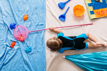 Studio shot of girl fishing with fishing net in water lying at beach