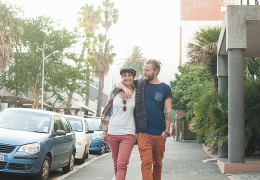 Couple walking with arm around on street