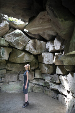 Italy, Alto Adige, Lana, woman standing in stone cave looking up
