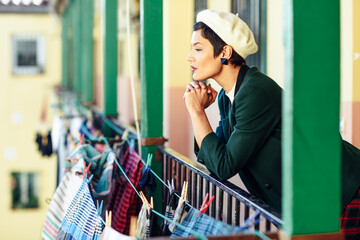 Fashionable young woman on porch of an apartment building