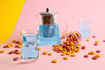 Cup of hot tea and cereal rings on color background