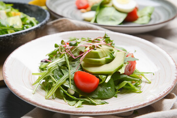 Plate with healthy salad on color wooden background