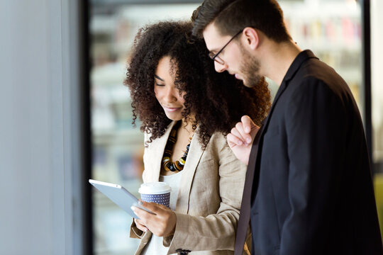 Two young business partners using a tablet in a hallway - Powered by Adobe
