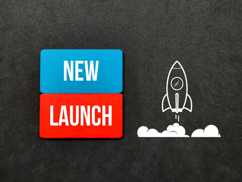 Colored wooden board, rockets and new launch words on black background.