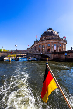 Germany, Berlin, Bode Museum and German flag on excursion boat on River Spree