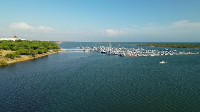 Yacht Club on Piedras River and Docks with lots of different vessels, Sailboats, Ships, yachts Moored in Puerto Marina El Rompido, Spain in Fall Season, Aerial slow orbite motion
