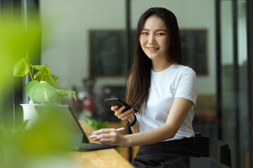Young asian female in a coffee shop sitting in co-working space