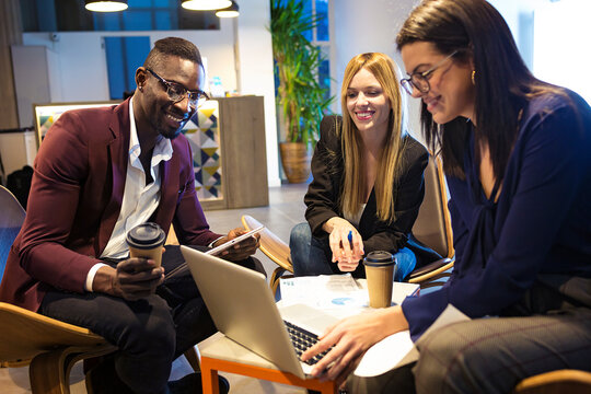 Business people sitting in a hotel lobby, working together