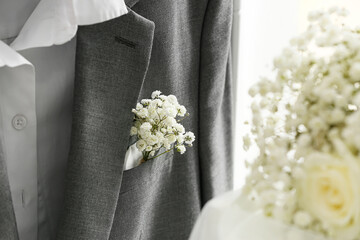 Beautiful white gypsophila boutonniere on groom's suit, closeup